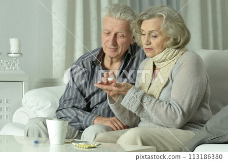 Close up portrait of sick senior man holding inhaler Close up portrait of sick senior man holding inhaler 113186380