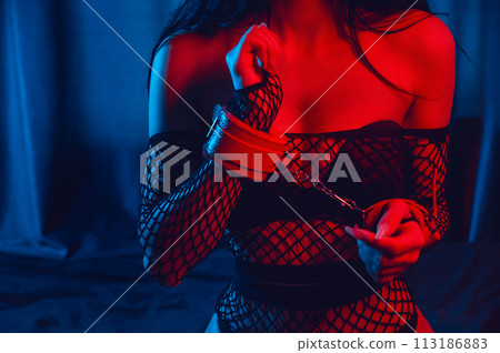 submissive woman with sexy body with hands in leather BDSM handcuffs. Bottom slave girl sitting in underwear on bed. Sex with submission and domination submissive woman with sexy body with hands in leather BDSM handcuffs. Bottom slave girl sitting in underwear on bed. Sex with submission and domination 113186883