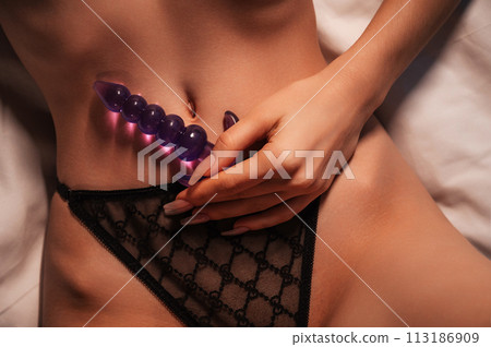 anal plug trainer silicone butt anal plug in a woman's hand on... - Stock Photo [113186909]