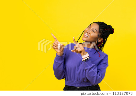 Young Woman Pointing Upwards on Yellow Background Young Woman Pointing Upwards on Yellow Background 113187073