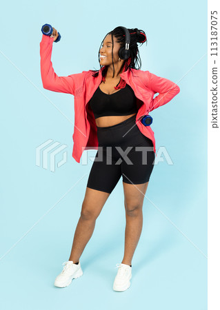 Active Woman Lifting Dumbbells While Smiling Active Woman Lifting Dumbbells While Smiling 113187075