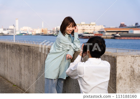Couple taking photos at the beach 113188160