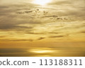 Sunset and ocean seen through the clouds 113188311