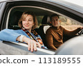Adult couple on a autumn road trip, man and woman sitting in the car and looking through the window 113189555
