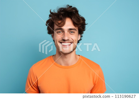 A man with a bright orange shirt is smiling at the camera 113190627