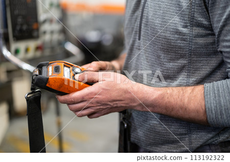 Factory worker. Technician controlling a heavy crane in factory, close up at his hands holding a 113192322