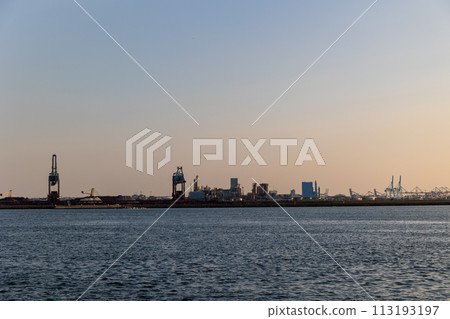 Ships float across the North Sea. Windmills in the background. Sea port in the Netherlands. A lot of cranes for loading goods. Different ships and barges. Ships float across the North Sea. Windmills in the background. Sea port in the Netherlands. A lot of cranes for loading goods. Different ships and barges. 113193197