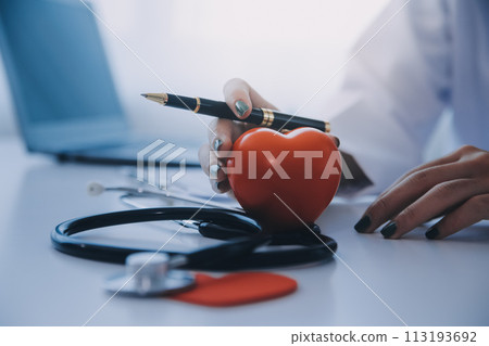 Doctor explaining heart to elderly patient. Doctor explaining the heart model. Doctors pen point to a model of the heart Doctor explaining heart to elderly patient. Doctor explaining the heart model. Doctors pen point to a model of the heart 113193692