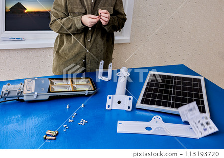 Customer prepares to mount an LED street light and solar panel to mounting bracket. 113193720