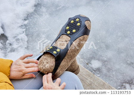 Overshoes with spikes are added to felted boots to prevent slipping on icy pavement and improve traction. 113193753