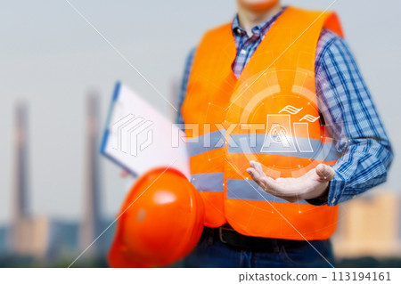 Worker in uniform shows nuclear power plant symbol . 113194161