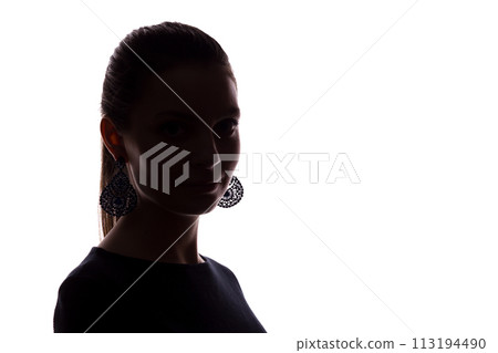 Young girl with earrings looks straight ahead, portrait isolate silhouette 113194490
