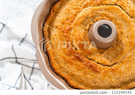 The freshly baked Carrot Bundt Cake is left to cool on the kitchen counter, filling the air with delightful aromas. 113194545