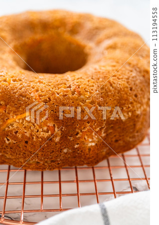 The freshly baked Carrot Bundt Cake is left to cool on the kitchen counter, filling the air with delightful aromas. 113194558