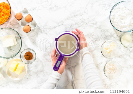 The vegetable shortening is expertly melted for greasing the bundt cake pan, setting the stage for baking this delicious cake. 113194601