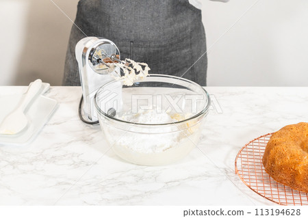 In a large mixing bowl, the ingredients are expertly mixed to create a delectable cream cheese buttercream for the Carrot Bundt Cake. 113194628