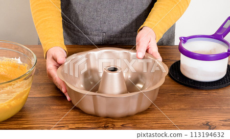 Carefully greasing a bundt cake pan in preparation for baking a delicious gingerbread bundt cake with caramel frosting. Carefully greasing a bundt cake pan in preparation for baking a delicious gingerbread bundt cake with caramel frosting. 113194632