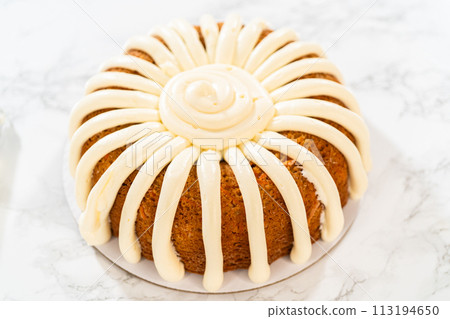 The freshly baked Carrot Bundt Cake is beautifully frosted with a luscious layer of cream cheese frosting. 113194650
