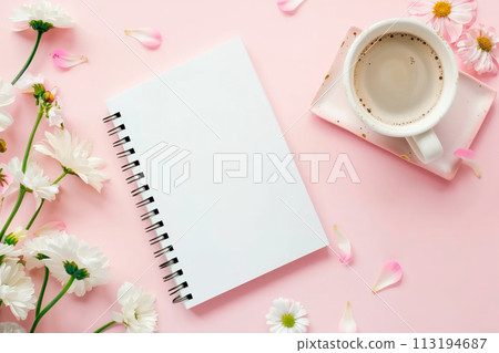 Flat lay with copy space of empty notebook on the table and flowers and a cup of coffee on a light background 113194687