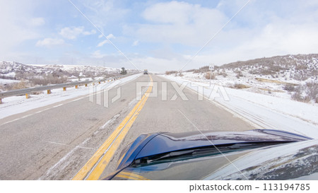 Navigating a frontage road post-winter storm offers a serene drive. The surrounding landscape, blanketed in snow, contributes to the peaceful and picturesque environment, enhancing the driving Navigating a frontage road post-winter storm offers a serene drive. The surrounding landscape, blanketed in snow, contributes to the peaceful and picturesque environment, enhancing the driving 113194785