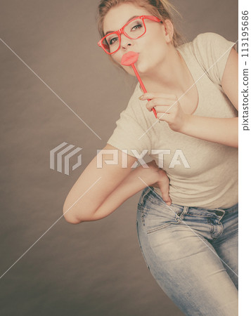 Happy woman holding fake lips on stick 113195686