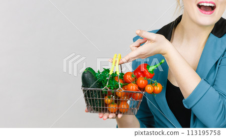 Woman holds shopping basket with vegetables 113195758