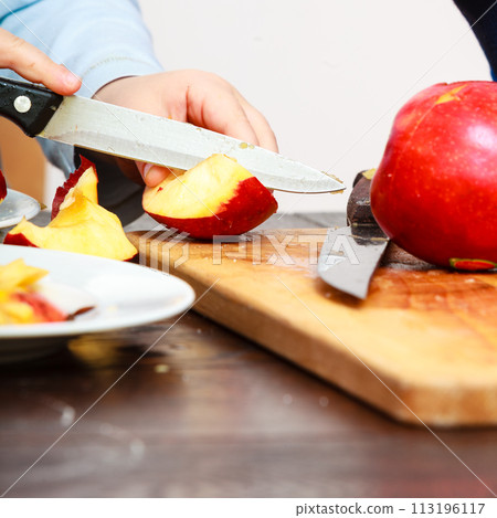 child cut apple with a kitchen knife 113196117