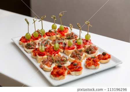 Plate with various seafood and meat canapes. 113196296
