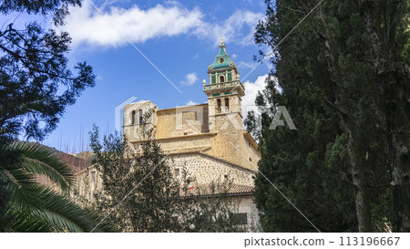 Carthusian Monastery of Valldemossa Peeking Through Verdant Trees in Mallorca Carthusian Monastery of Valldemossa Peeking Through Verdant Trees in Mallorca 113196667