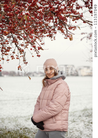 Winter Elegance: Portrait of a Beautiful Girl in a Snowy European Village. Winter lifestyle portrait of cheerful pretty girl. Smiling and having fun in the snow park. Snowflakes falling down Winter Elegance: Portrait of a Beautiful Girl in a Snowy European Village. Winter lifestyle portrait of cheerful pretty girl. Smiling and having fun in the snow park. Snowflakes falling down 113197849