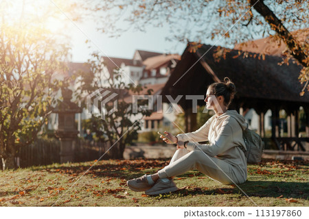 Young Fashionable Teenage Girl With Smartphone In Europian Park In Autumn Sitting At Smiling. Trendy Young Woman In Fall In Park Texting. Retouched, Vibrant Colors. Beautiful Blonde Teenage Girl Young Fashionable Teenage Girl With Smartphone In Europian Park In Autumn Sitting At Smiling. Trendy Young Woman In Fall In Park Texting. Retouched, Vibrant Colors. Beautiful Blonde Teenage Girl 113197860