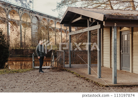 Timeless Elegance: 40-Year-Old Man in Stylish Jacket by Neckar River and Historic Bridge in Bietigheim-Bissingen, Germany Timeless Elegance: 40-Year-Old Man in Stylish Jacket by Neckar River and Historic Bridge in Bietigheim-Bissingen, Germany 113197874