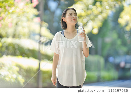 穿著運動服的年輕女子用塑膠瓶喝水 113197986