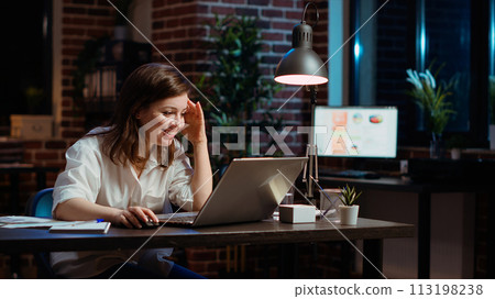 Happy employee reading email on laptop received from customer, excited after managing to secure lucrative deal for company. Businesswoman celebrating finalizing agreement with client, camera B 113198238