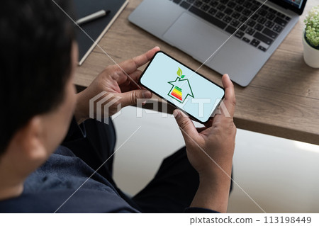Businessman use phone Energy efficiency mobile app on screen Chart And House Businessman use phone Energy efficiency mobile app on screen Chart And House 113198449