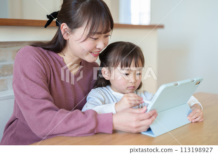 一個女孩和她的母親在平板電腦上畫畫 一個女孩和她的母親在平板電腦上畫畫 113198927