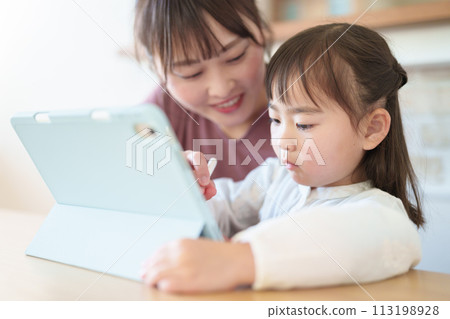 Girl and mother drawing on tablet 113198928