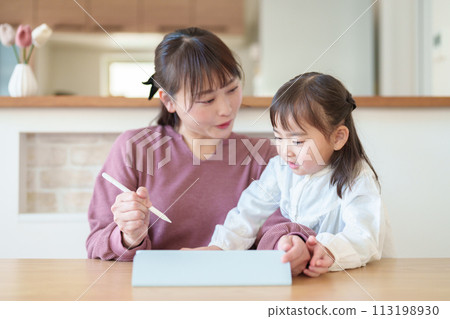 Girl and mother drawing on tablet 113198930