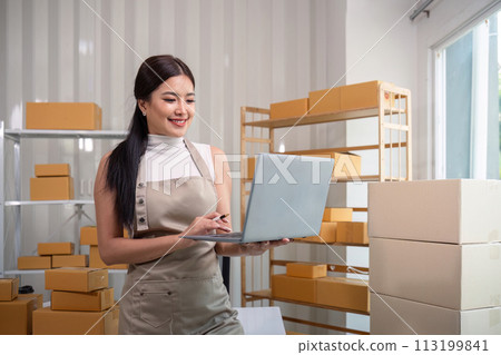Young business woman asian working online ecommerce shopping at her shop. Young woman sell prepare parcel box of product for deliver to customer. Online selling 113199841