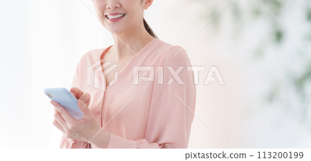Woman operating a smartphone Woman operating a smartphone 113200199