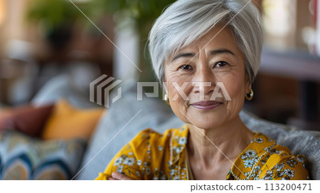 Mature Asian woman sitting at home on couch, indoor portrait 113200471