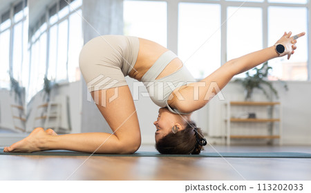 Lover of active lifestyle on yoga mat perform doing shashankasana in gym Lover of active lifestyle on yoga mat perform doing shashankasana in gym 113202033