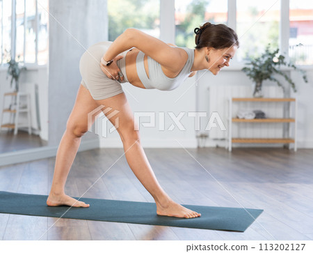 Young woman practicing yoga asanas in studio Young woman practicing yoga asanas in studio 113202127