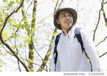 A young man enjoying hiking in the fresh greenery 113203297