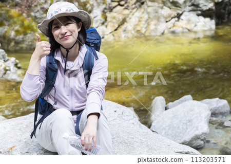 A woman enjoying a hike in fresh greenery 113203571