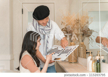 A woman choosing a color after looking at hair color samples at a beauty salon/hair salon/beauty salon A woman choosing a color after looking at hair color samples at a beauty salon/hair salon/beauty salon 113203795