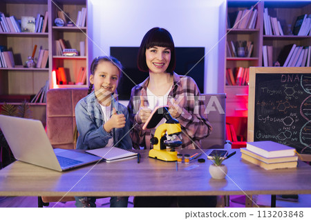Caucasian women wearing casual clothes making scientific research at home. 113203848