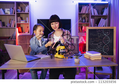 Caucasian women wearing casual clothes making scientific research at home. 113203856