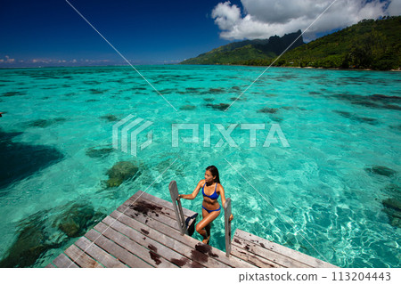 Luxury beach travel vacation woman in Tahiti overwater bungalow hotel villa swimming. This image is completely unretouched and unedited and model is with no makeup. Original Raw Image Luxury beach travel vacation woman in Tahiti overwater bungalow hotel villa swimming. This image is completely unretouched and unedited and model is with no makeup. Original Raw Image 113204443