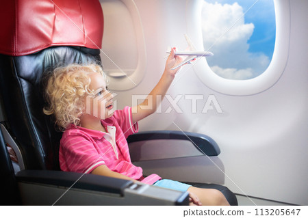 Child flying in airplane. Flight with kids. 113205647